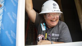 Volunteer smiling on a build site.