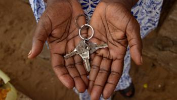 Two palms are open and holding a key chain with multiple keys.