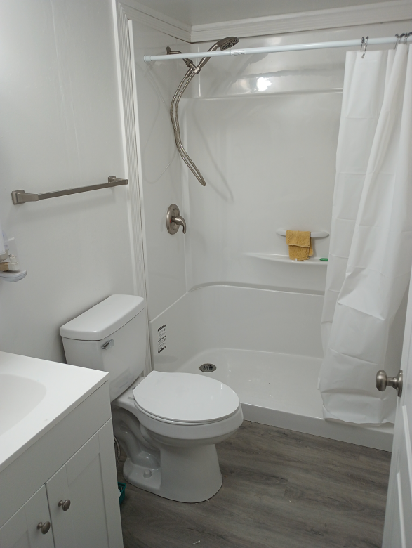 A renovated bathroom now includes a new vanity, toilet and accessible shower.