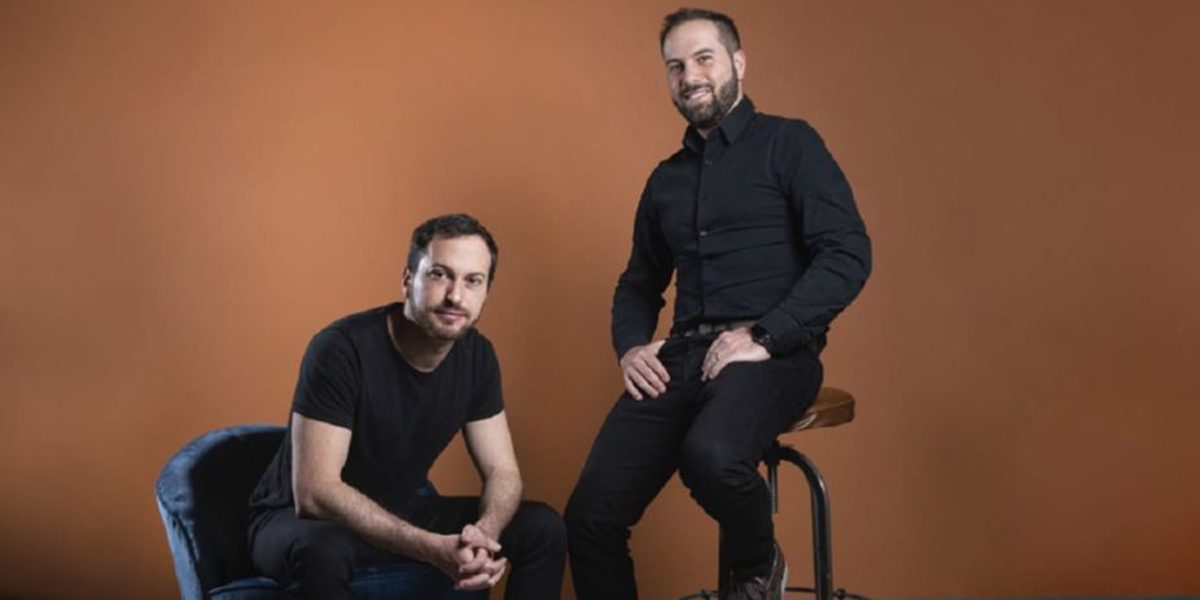 Two men posing for a promotional photo.