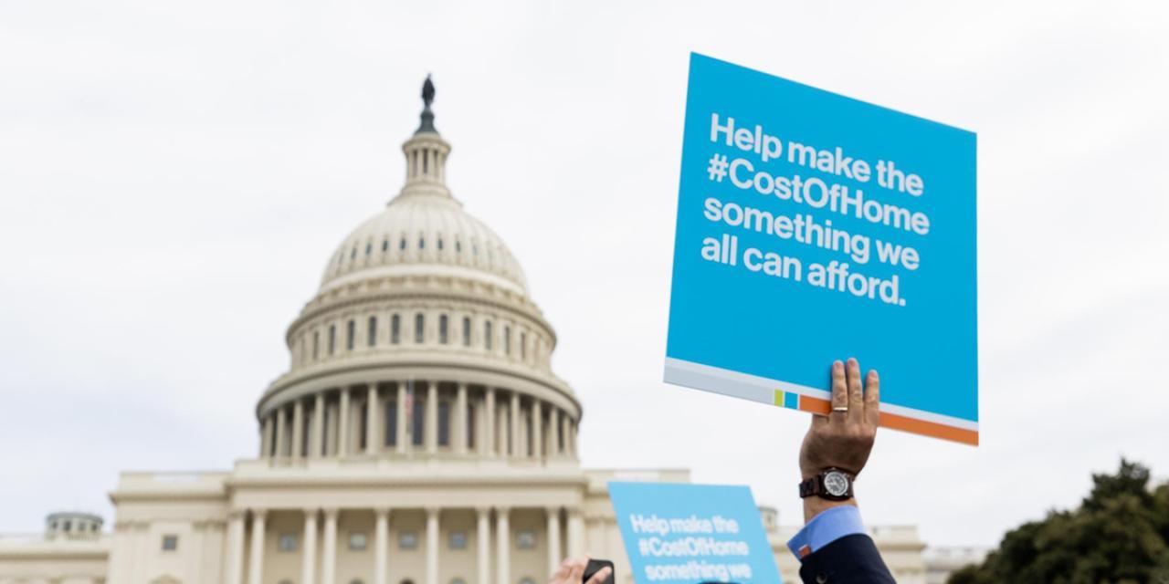 ​​​​Cost of home demonstration sign in front of capitol building