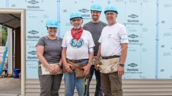Stoesz family stands together on the build site.