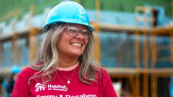 Juanita on the buildsite, smiling softly as she looks to the side.