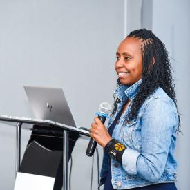 Side profile photo of a lady speaking through a microphone