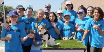 A team stands in front of their DIY doghouse