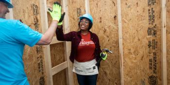 Homeowner high-fives a volunteer.