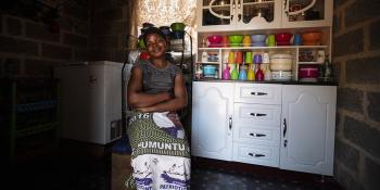 Habitat homeowner Lucy smiling in a chair inside her home.