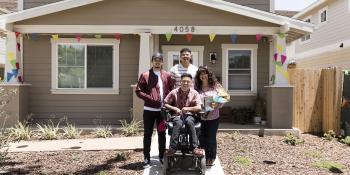 Mulvihills family smiling in front of their new accessible Habitat home.
