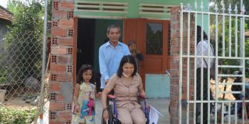 Binh and her daughter in front of her wheelchair accessible Habitat home.