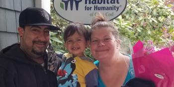 Jennifer and family smiling in front of home