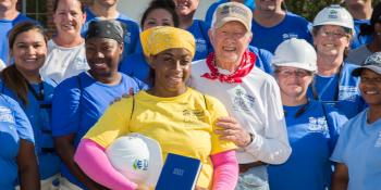 President Carter standing next to a Habitat homeowner and build team