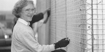 Black and white photo from 1990 of Rosalynn Carter smiling while working on the build site 