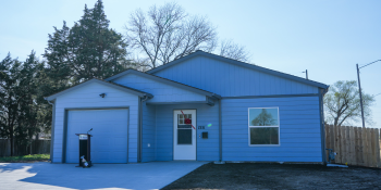 New light blue Habitat house with red bow on the front door.