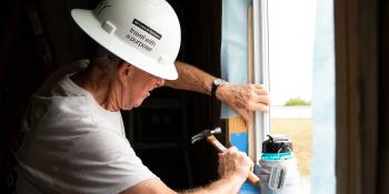 A volunteer hammering on a build site.