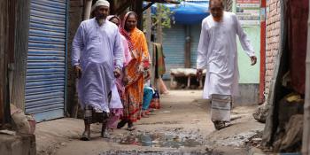 aje and Mohosin walk through Beguntila to discuss a current sewage drainage issue that is a top priority for repair by the community leaders.