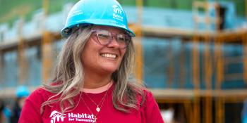 Juanita on the buildsite, smiling softly as she looks to the side.