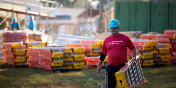 Volunteer carrying ladder.