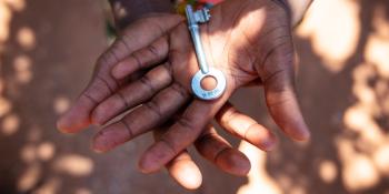 A close-up of a child's hands holding a key.