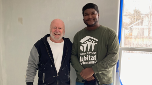 Two volunteers stand inside a home they are renovating in Eastern Jackson County, Missouri.