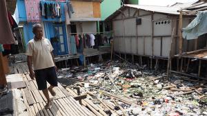 Wardi walking in informal settlement in north Jakarta, Indonesia