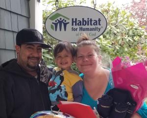 Jennifer posing in front of Habitat house with family