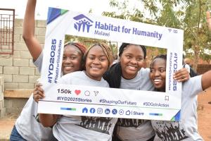 Women holding a photo frame in front of a build site