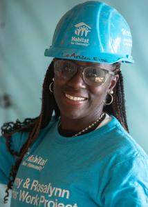 LeAndra holding a tool inside a home being built.