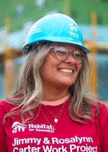 Juanita on the buildsite, smiling softly as she looks to the side.