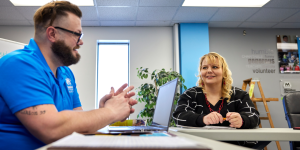 Habitat staff member and woman talking to each other in a classroom setting