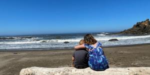 Two children embracing on the beach.