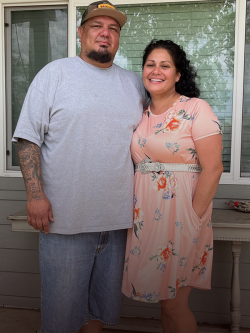 Couple standing outside home.