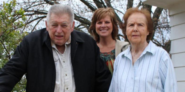 Leon, Lisa, and Loretta in front of their repaired home.