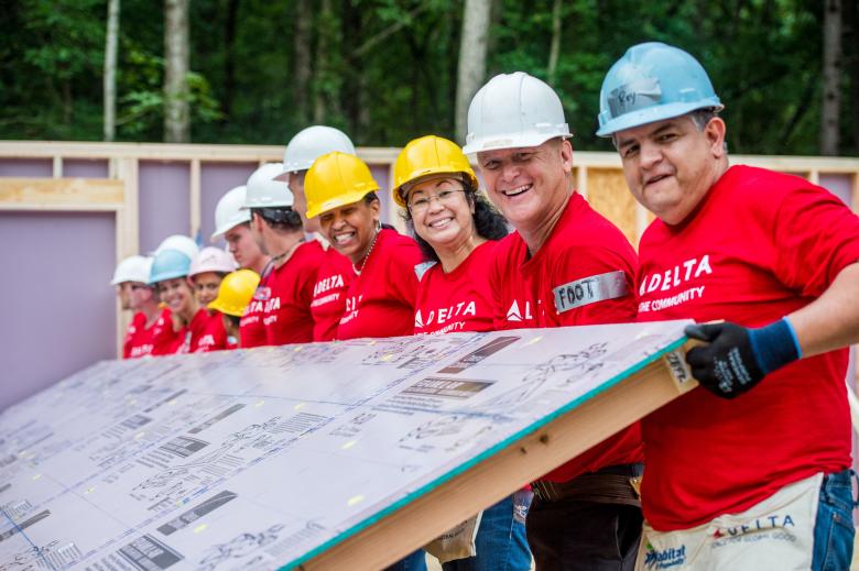 Delta volunteers raising a wall.