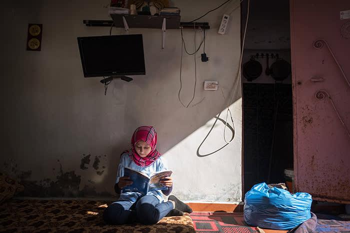 photo by Financial TImes: Lara al-Khaled reading a book sitting on the floor