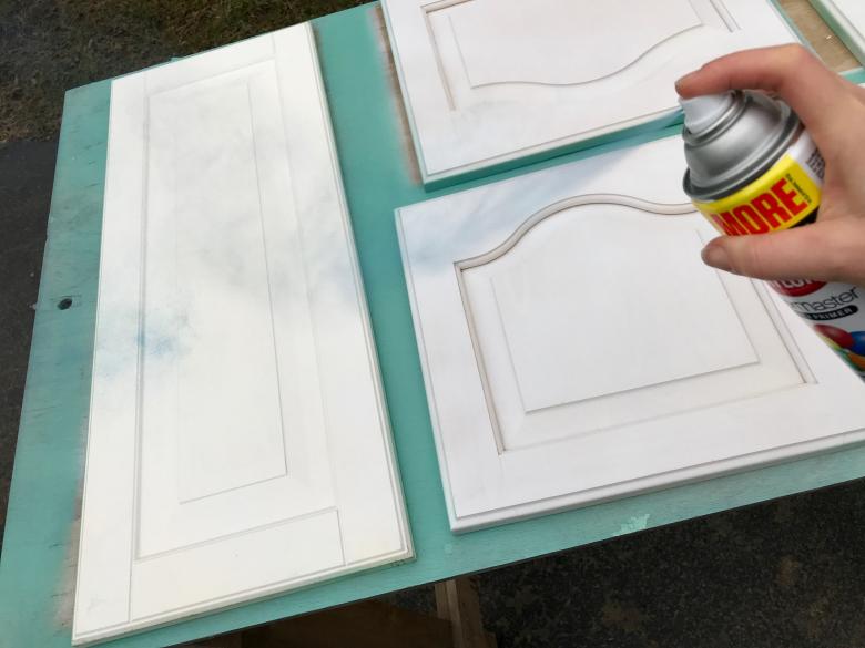 Theresa spray paints the cabinet doors.