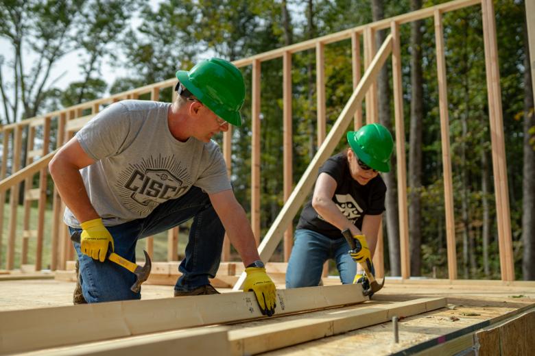 Two Cisco volunteers working on build site.