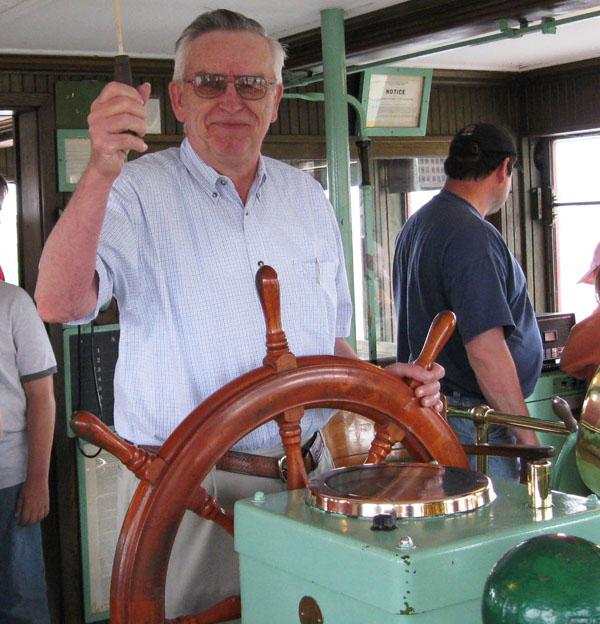 Ron Vandeveld on a boat at the wheel.