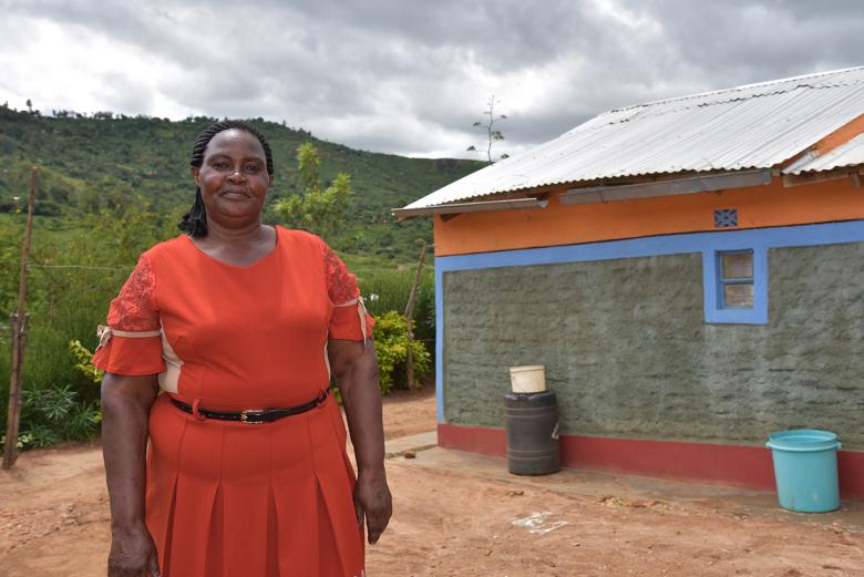 Photo: Jane Mueni Paul from Kenya standing in front of her newly built house