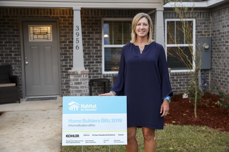 Alicia Huey stands outside a Habitat home.