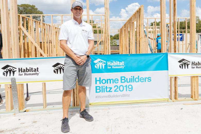 Jeff stands in front of a house that's being constructed. 