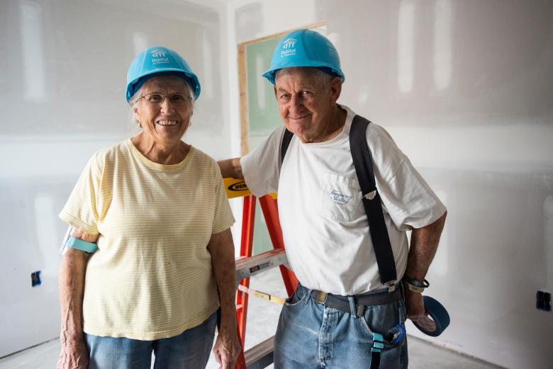 Barb and Steve stand together on the build site.