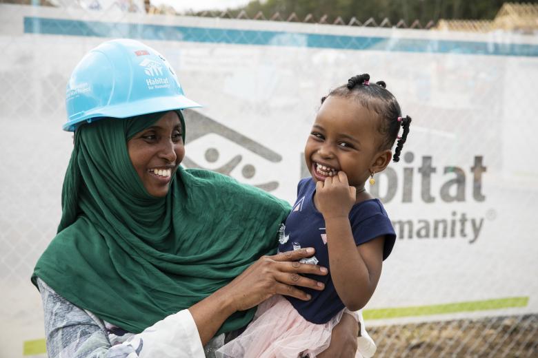 A homeowner holds her child. 