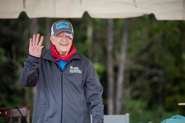 Jimmy Carter waves to volunteers on the build site.