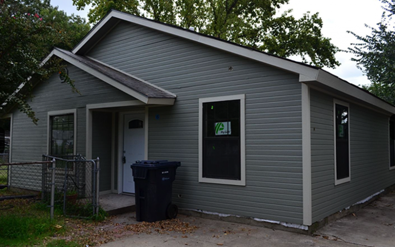 The same ranch home with all new siding and fresh grey paint.