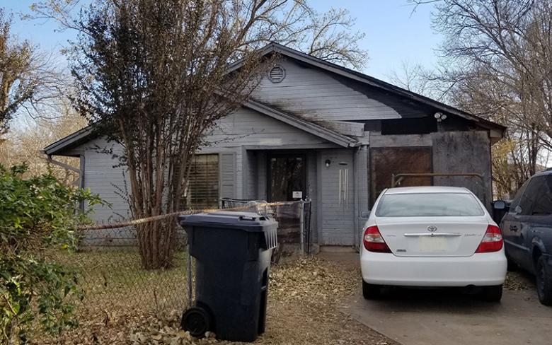 Ranch home with missing and deteriorating siding.