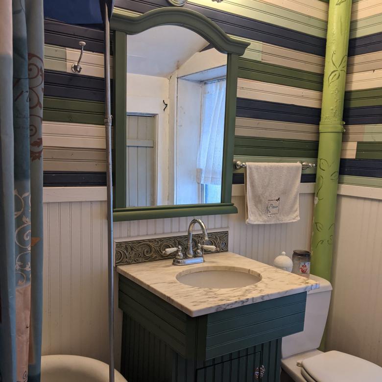 A bathroom redone with a sink and backsplash (tiles in stripes of gray, white and black) from the Topeka ReStore.