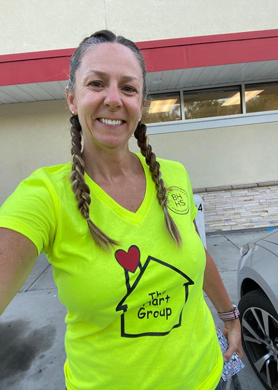 Sarah Hunt in a bright shirt with a house on it.