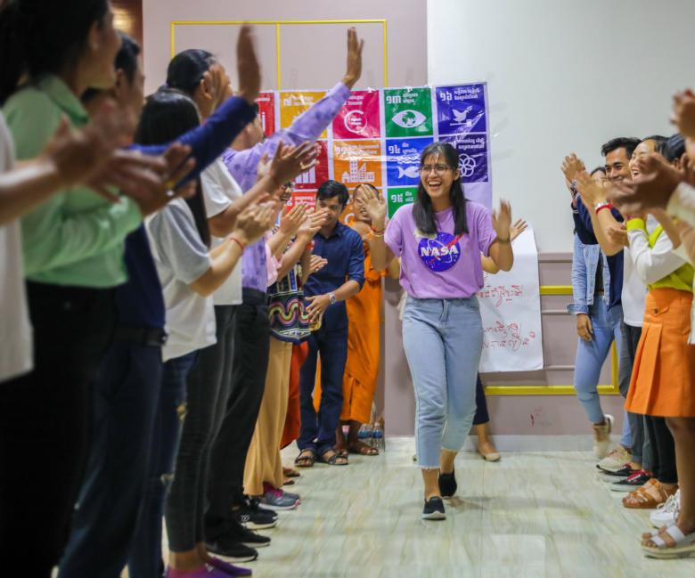 Volunteer trainer Kannika Nhem greeting crowd of volunteers