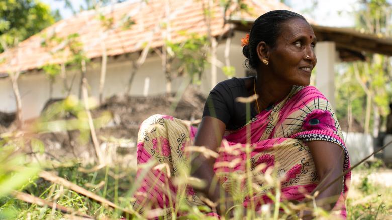 woman in pink sari sitting in garden