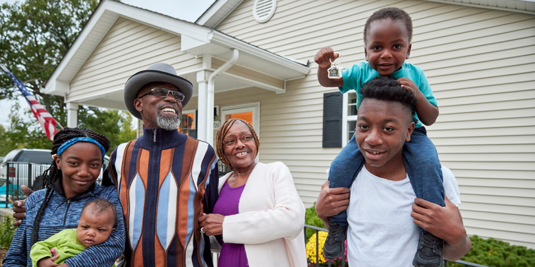 Regina and Larry with their grandchildren in front of their home.